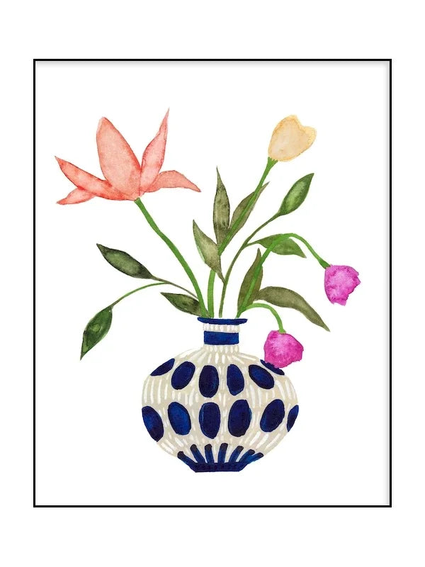 Decorative vase with polka dot pattern holding pink, yellow, and purple flowers on a white background.