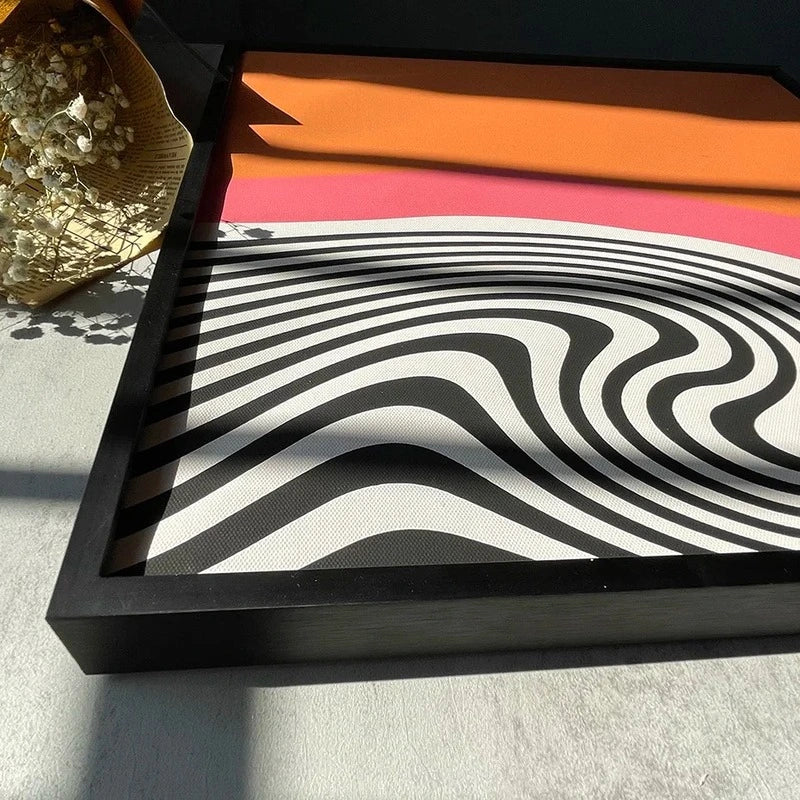 Framed artwork with black and white wavy pattern on a gray surface