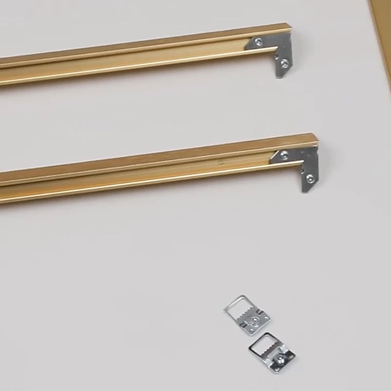 Two gold metal brackets with screws on a light gray background