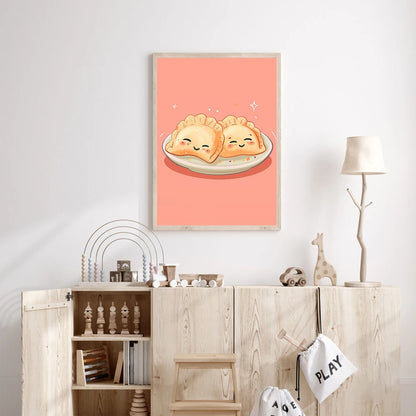 Framed artwork of two smiling dumplings on a plate against a pink background, hanging above a wooden cabinet.