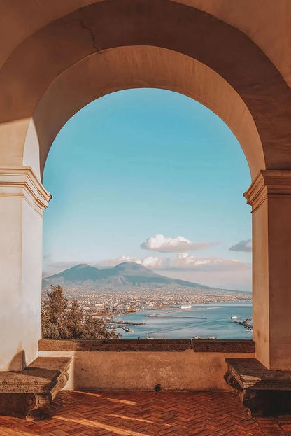Archway overlooking a coastal view with Mount Vesuvius in the distance