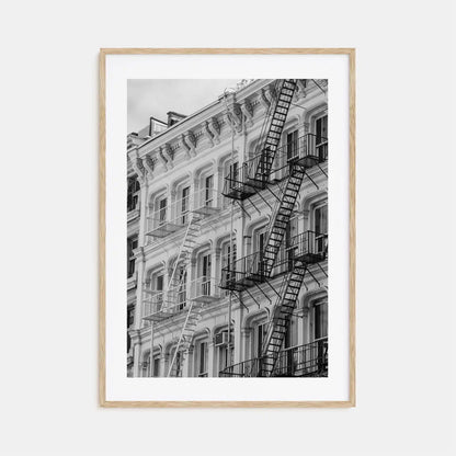 Framed black and white photograph of a building with fire escapes on a light gray background