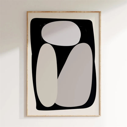 Abstract art print with geometric shapes in a wooden frame on a white wall