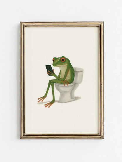 Framed artwork of a frog sitting on a toilet using a smartphone.