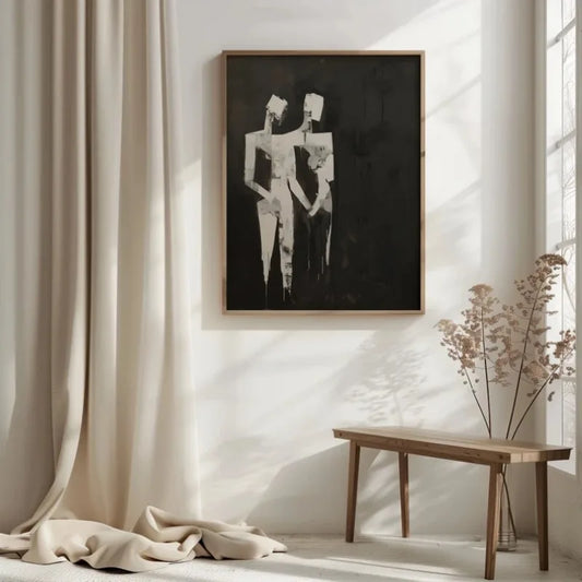 Framed black and white abstract art on a wall with a wooden table and draped fabric in a room. Canvas & Curio