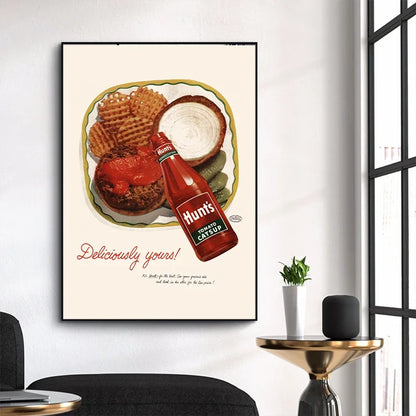 Framed poster of a burger and ketchup bottle with 'Hunt's' branding on a wall.