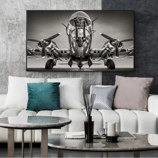 Canvas print of a vintage airplane on a wall above a white sofa with decorative pillows. Canvas & Curio