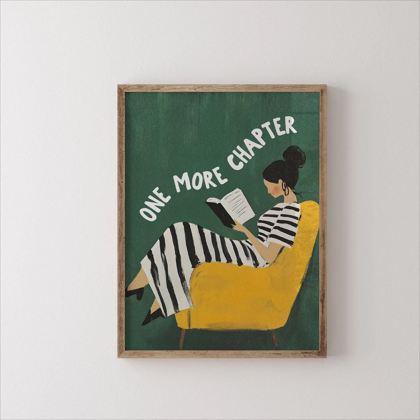 Framed artwork of a woman reading a book with 'One More Chapter' text on a green background.