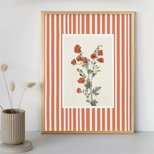 Framed botanical print with red flowers on a striped background, next to a vase with dried plants. Canvas & Curio