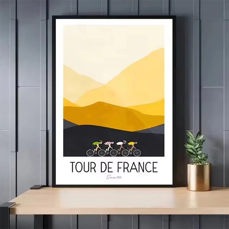 Framed 'Tour de France' poster with cyclists and mountain design on a wooden shelf.