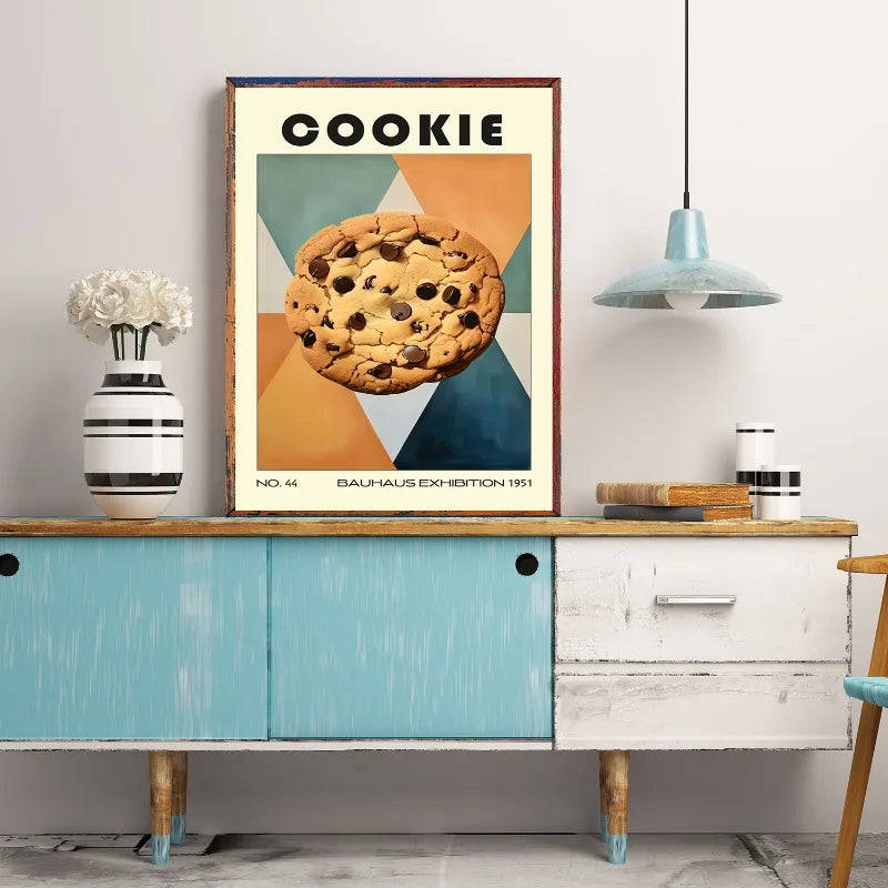Framed poster of a cookie on a wall above a wooden cabinet.