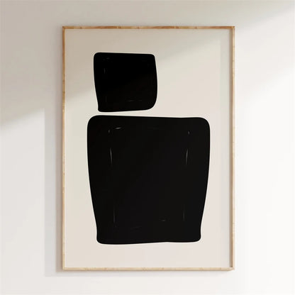 Framed abstract art with black shapes on a white wall