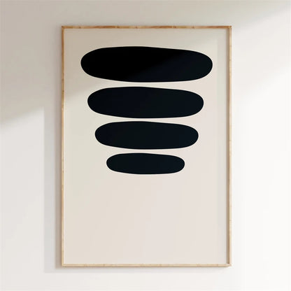 Framed abstract art with black shapes on a white wall