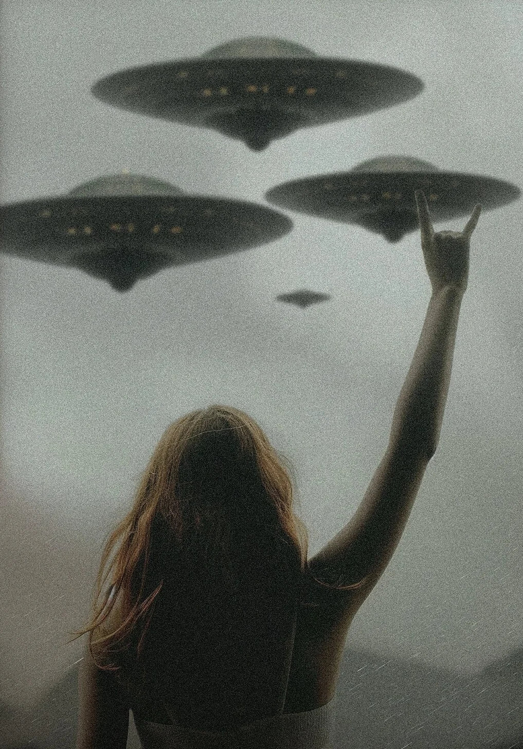 Person with outstretched arm facing three UFOs in a foggy sky