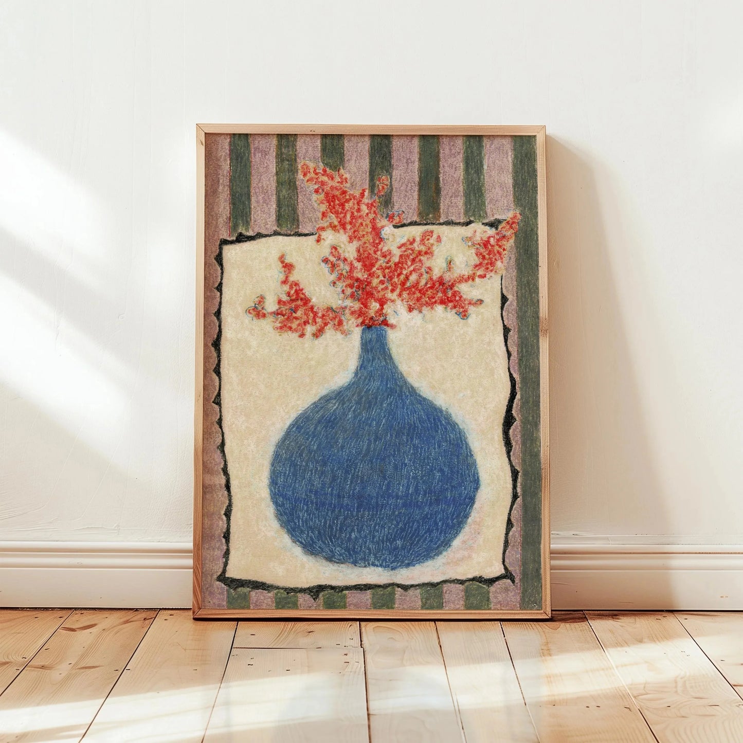 Framed artwork of a blue vase with red flowers on a white wall.