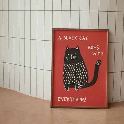 Framed poster with a black cat illustration and text on a red background against a tiled wall.