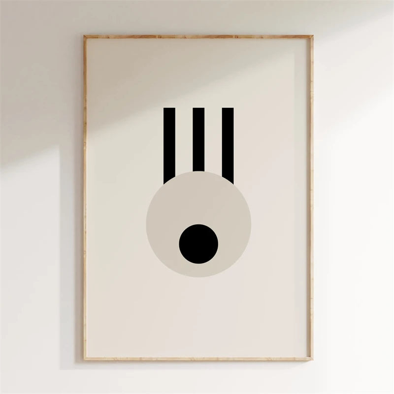 Framed abstract art print with black and white design on a beige wall.