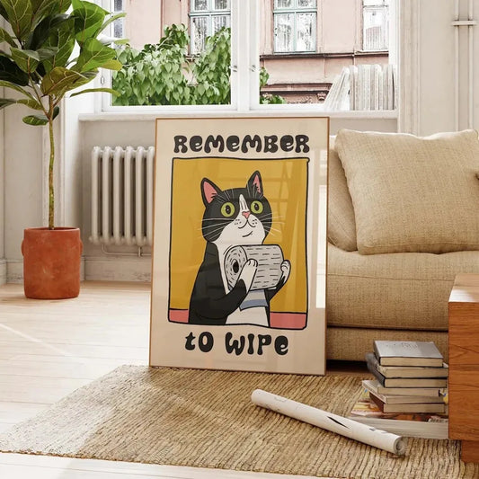 Poster with a cat illustration and text 'Remember to wipe' in a living room setting. Canvas & Curio
