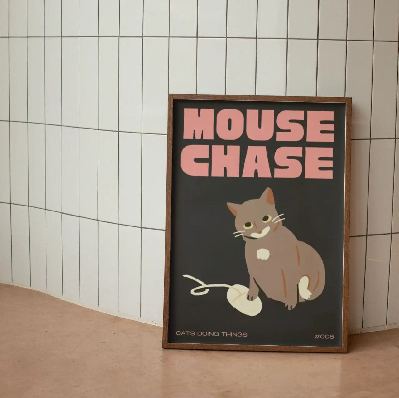 Framed poster with a cat illustration and 'Mouse Chase' text on a tiled wall.