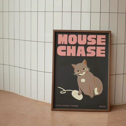 Framed poster with a cat illustration and 'Mouse Chase' text on a tiled wall.