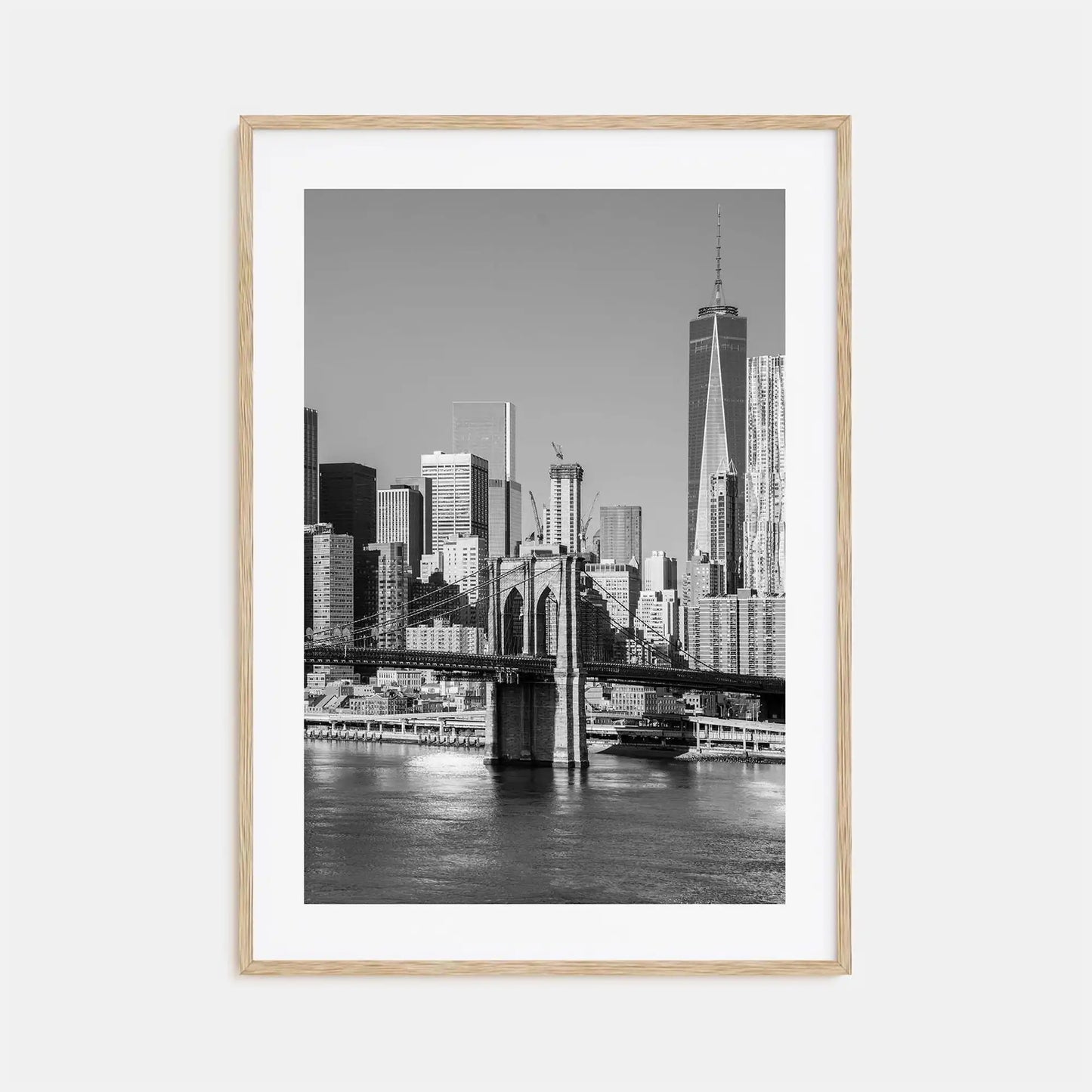 Framed black and white cityscape print of a skyline with a river and bridge.