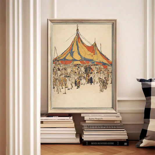 Framed artwork of a circus scene on a stack of books against a white wall. Canvas & Curio
