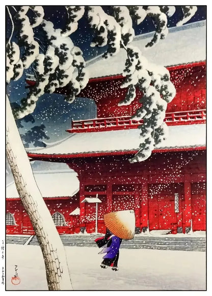 Traditional Japanese red temple gate with a person holding an umbrella during snowfall