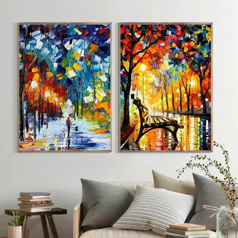 Two colorful abstract paintings of a park scene with a bench on a wall above a sofa.