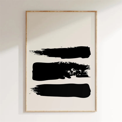 Framed abstract art with three black brush strokes on a white wall.