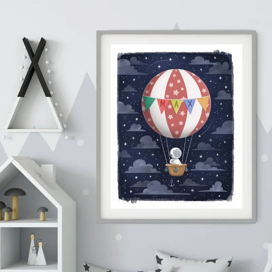 Framed artwork of a hot air balloon with colorful flags against a starry night sky, displayed on a wall. Canvas & Curio