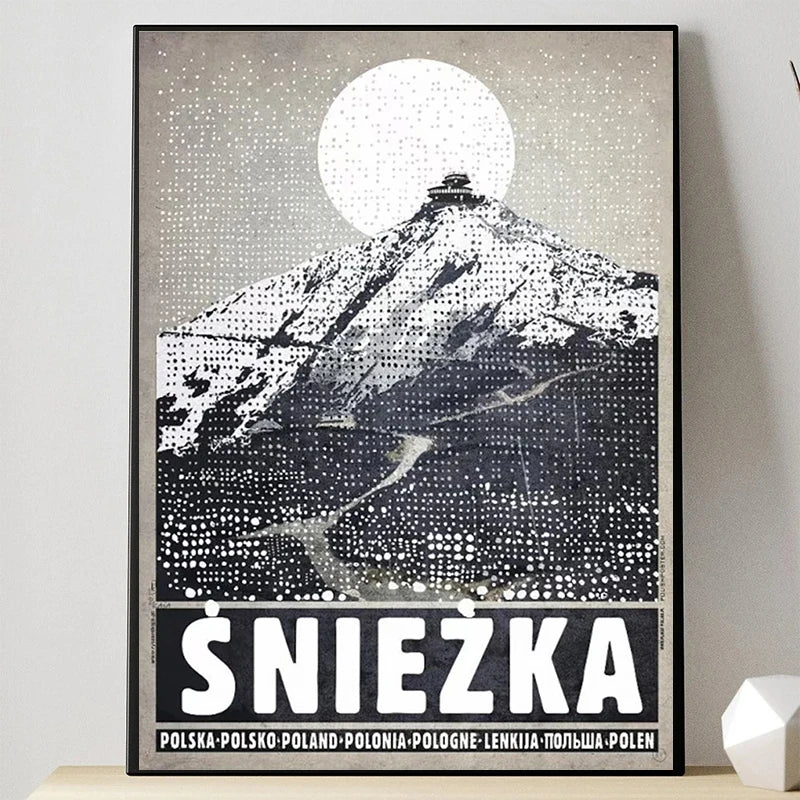 Framed poster of a mountain with 'Sniezka' at the bottom on a light gray wall.
