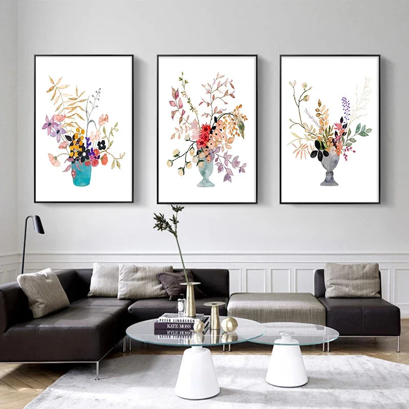 Three framed floral prints on a wall above a modern living room setup.