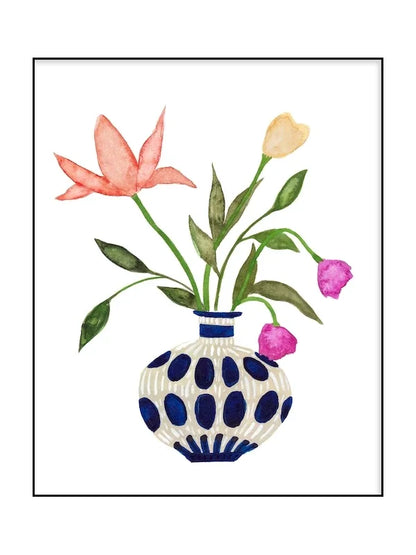 Decorative vase with polka dot pattern holding pink, yellow, and purple flowers on a white background.