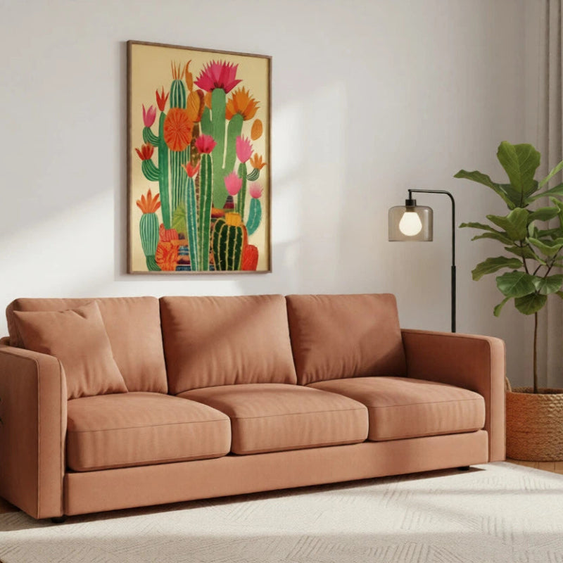 Brown sofa in a living room with a cactus painting on the wall.