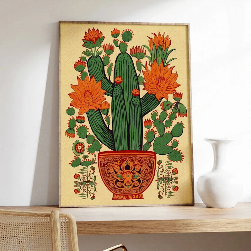 Framed artwork of a cactus with orange flowers on a shelf.