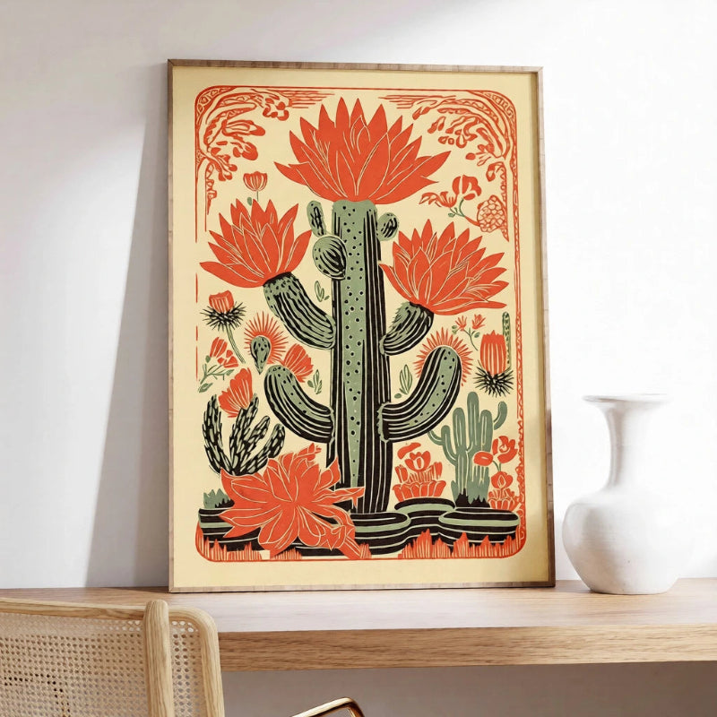 Framed artwork of a cactus with red flowers on a shelf.