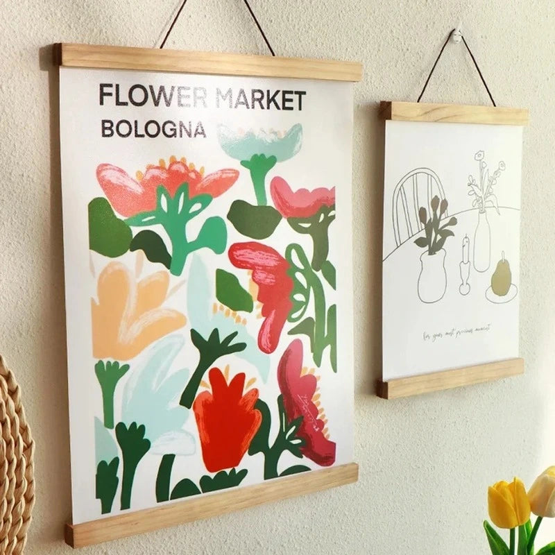 Floral-themed posters with wooden frames on a wall.